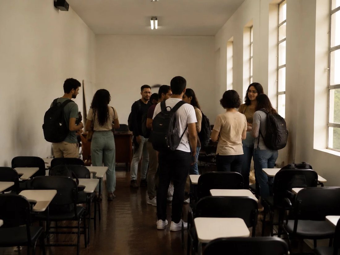 Colegas de mochila conversando no corredor antes de entrar na sala